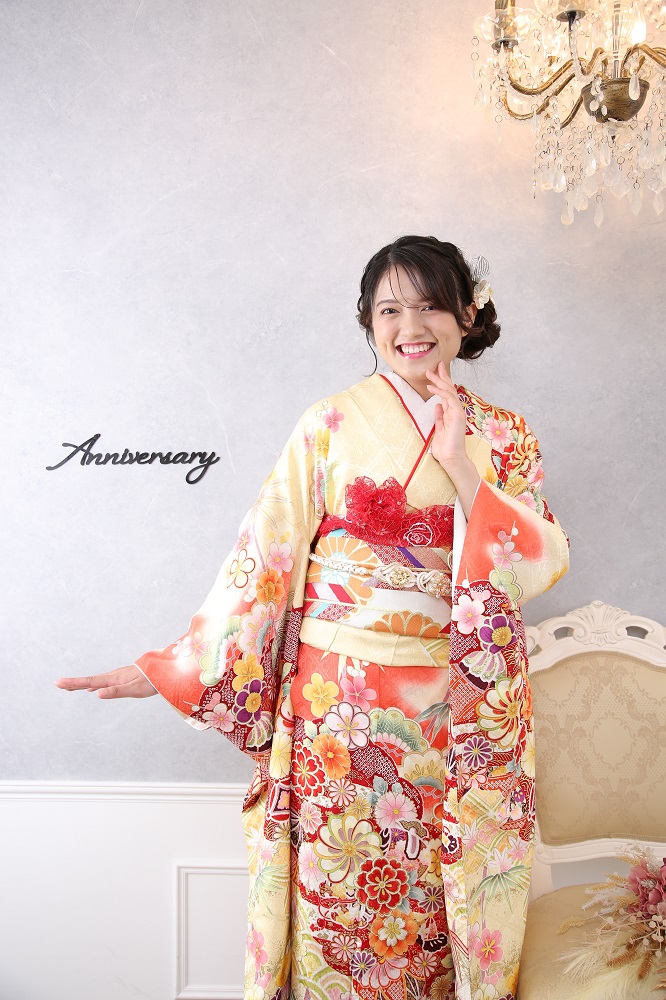 菊の花柄の黄色い振袖を着た女の子